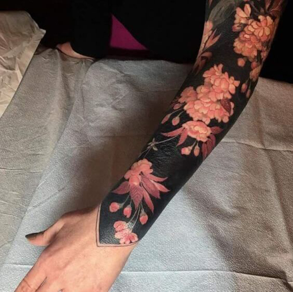 The Flowers Against a Black Backdrop Tattoo on skin