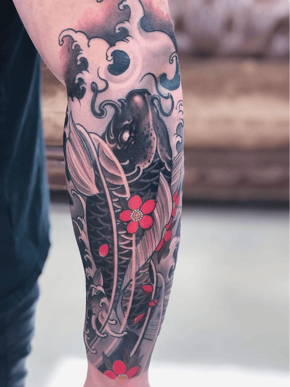 The Rising Koi Fish with Blossoms Tattoo on skin