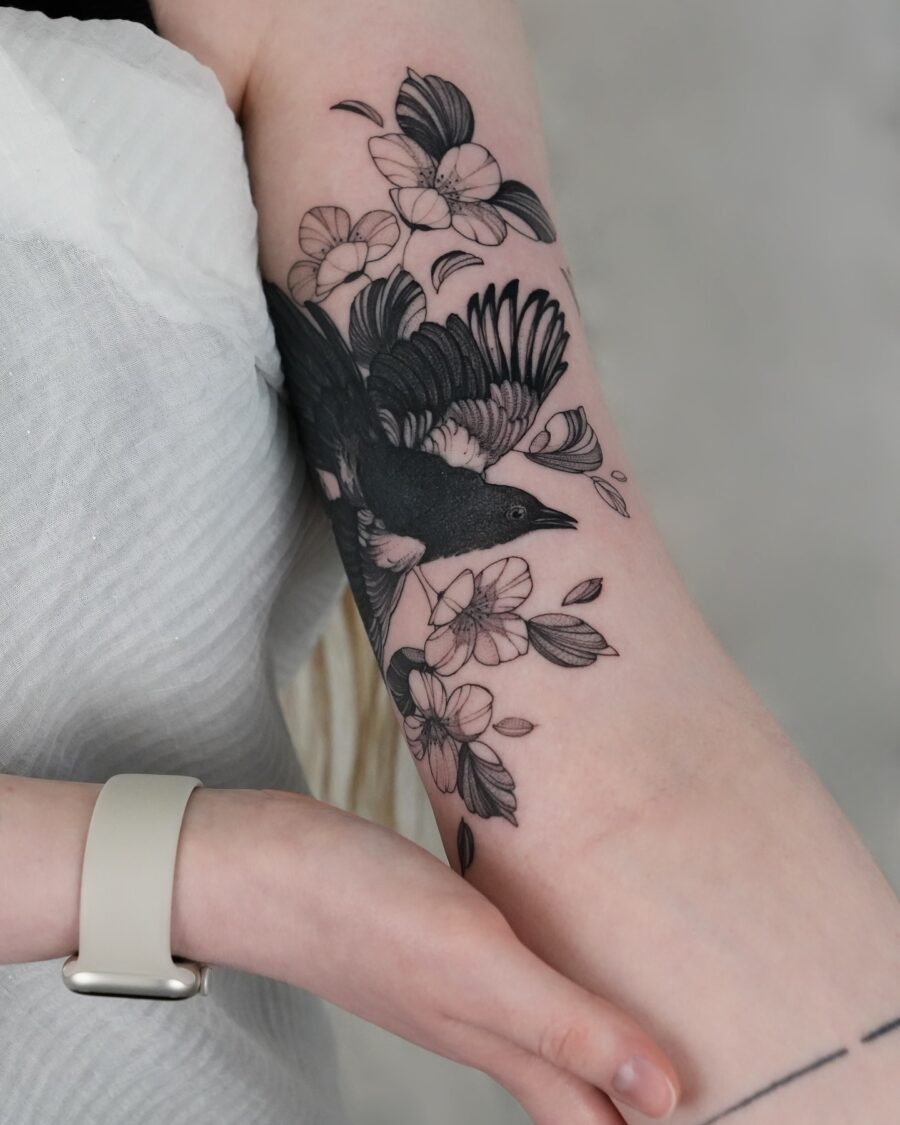 Elegant bird tattoo with floral elements Tattoo on skin