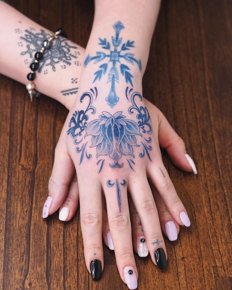 Elegant floral and cross tattoo design on hand Tattoo on skin