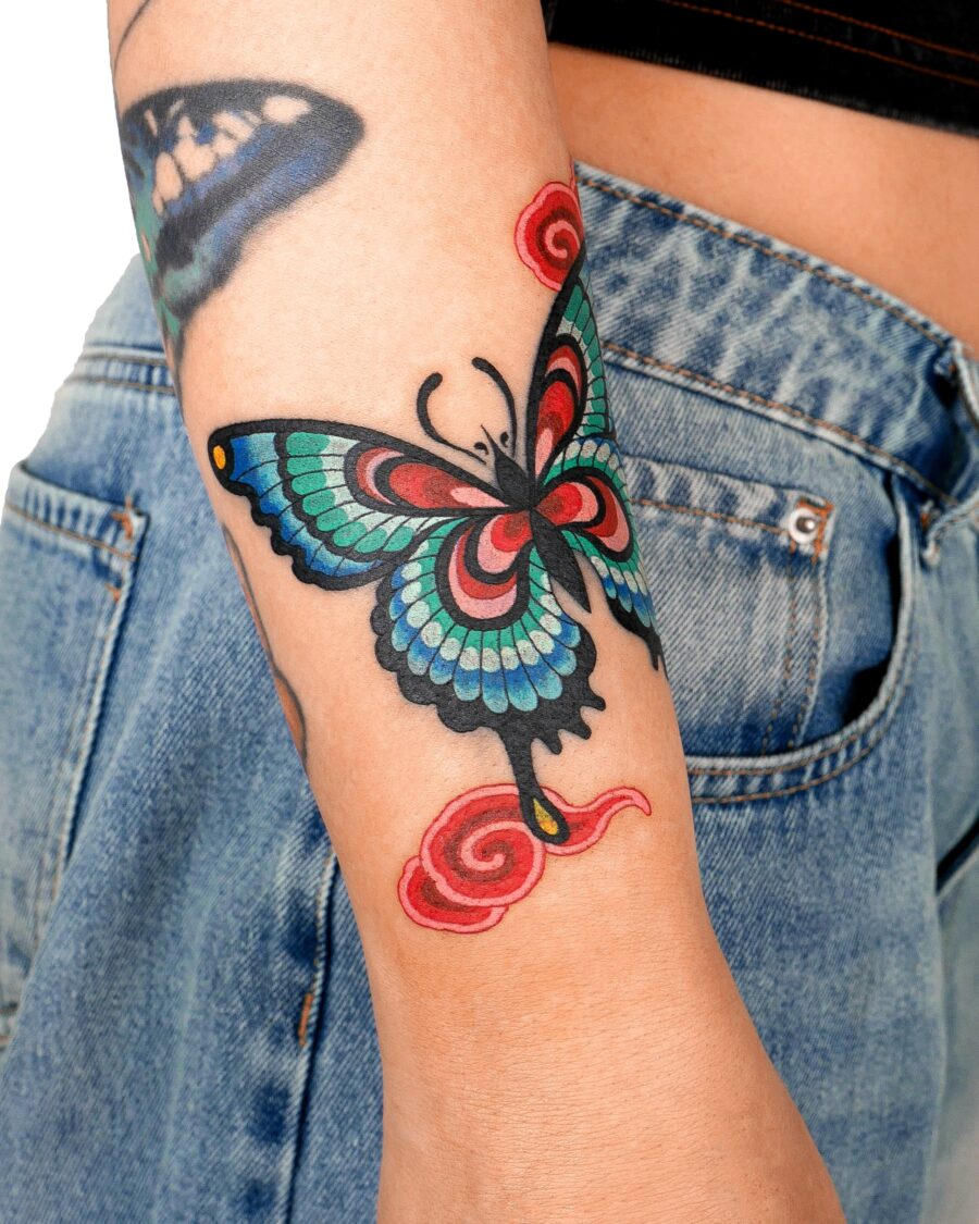 Vivid butterfly tattoo with swirling accents Tattoo on skin