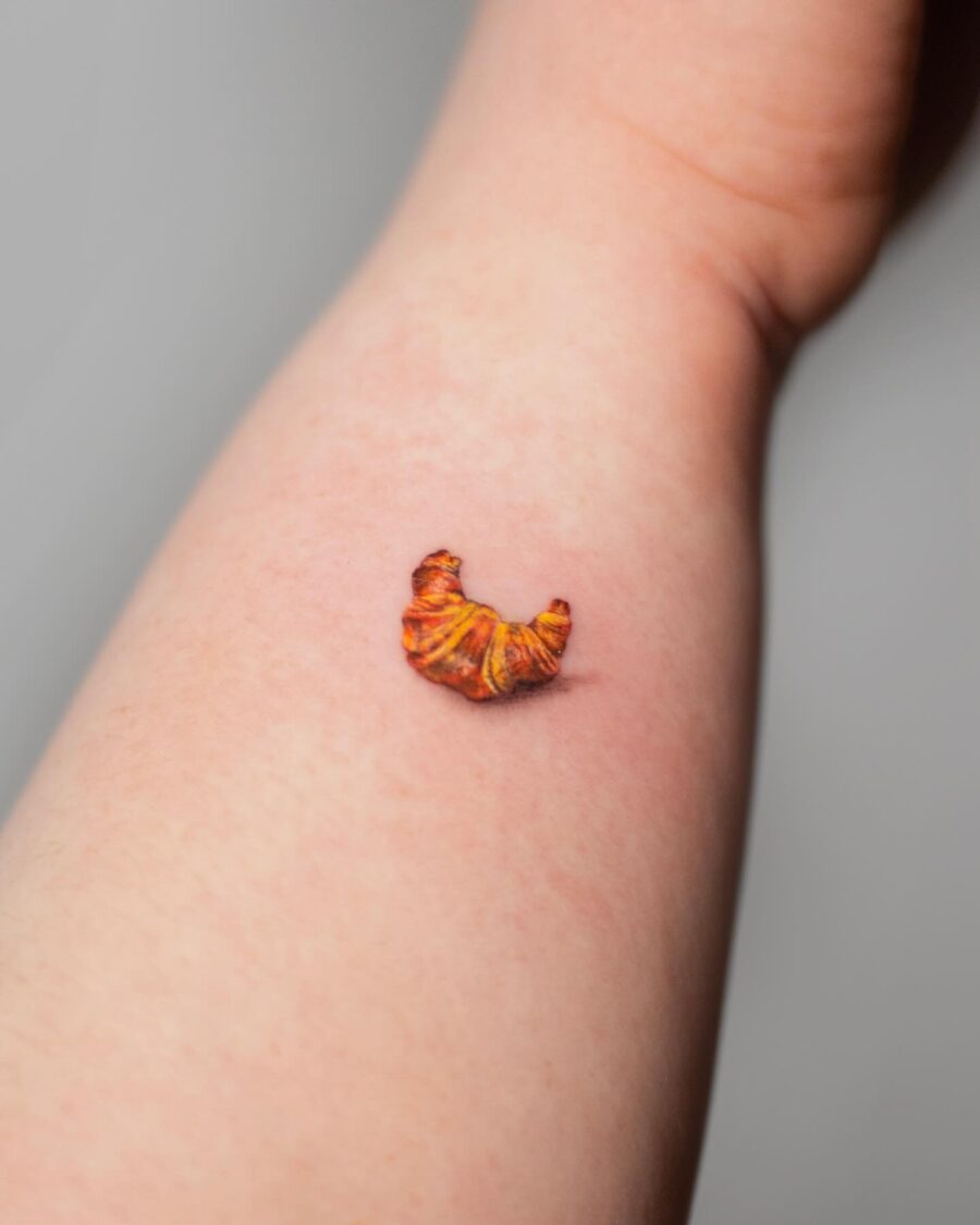A Charming Croissant Tattoo on the Forearm Tattoo on skin