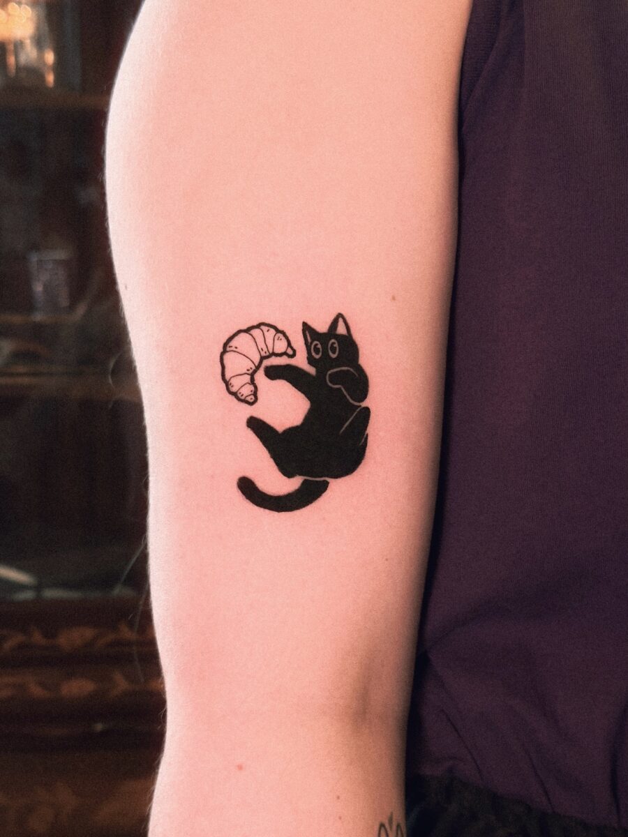 Charming cat with croissant tattoo design Tattoo on skin