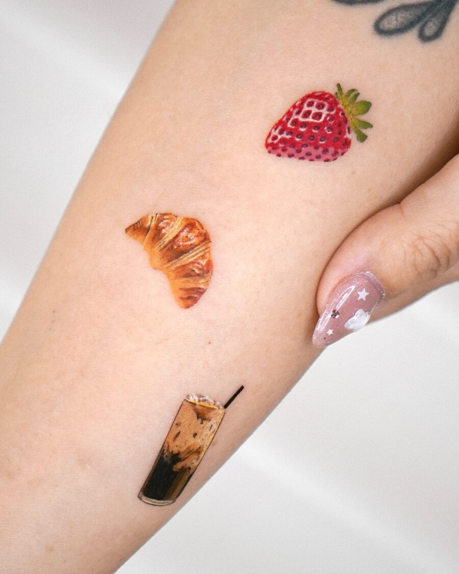 Charming croissant tattoo among tasty treats Tattoo on skin