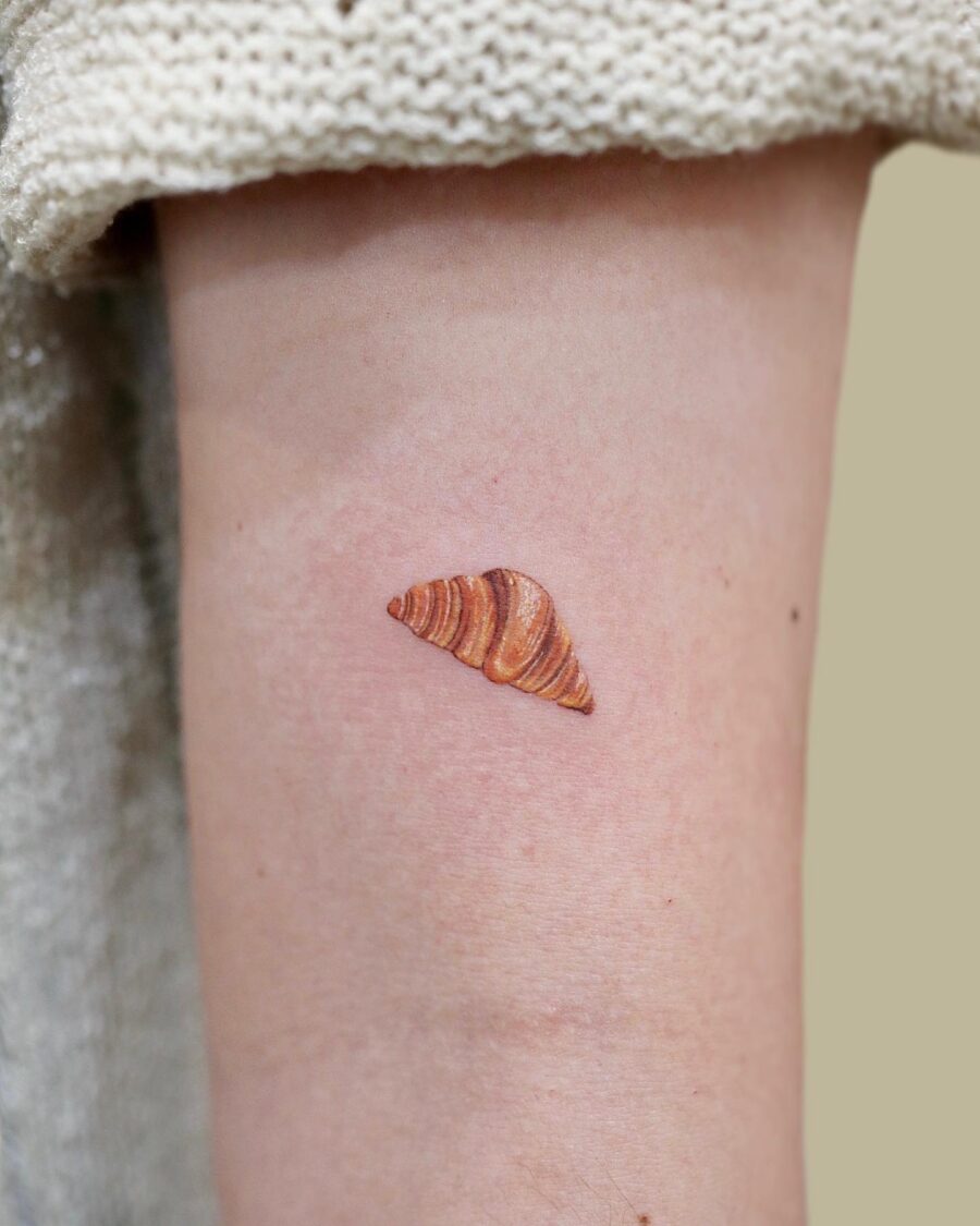 Charming croissant tattoo for food lovers Tattoo on skin