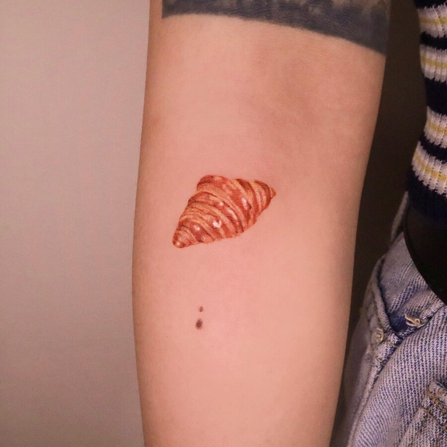 Charming croissant tattoo on a forearm Tattoo on skin