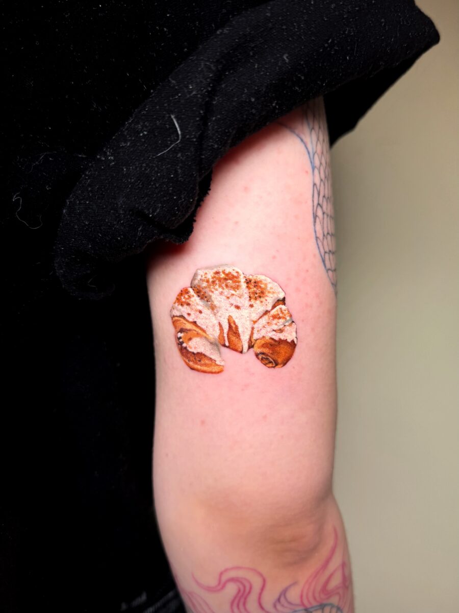Charming croissant tattoo on an elegant arm Tattoo on skin