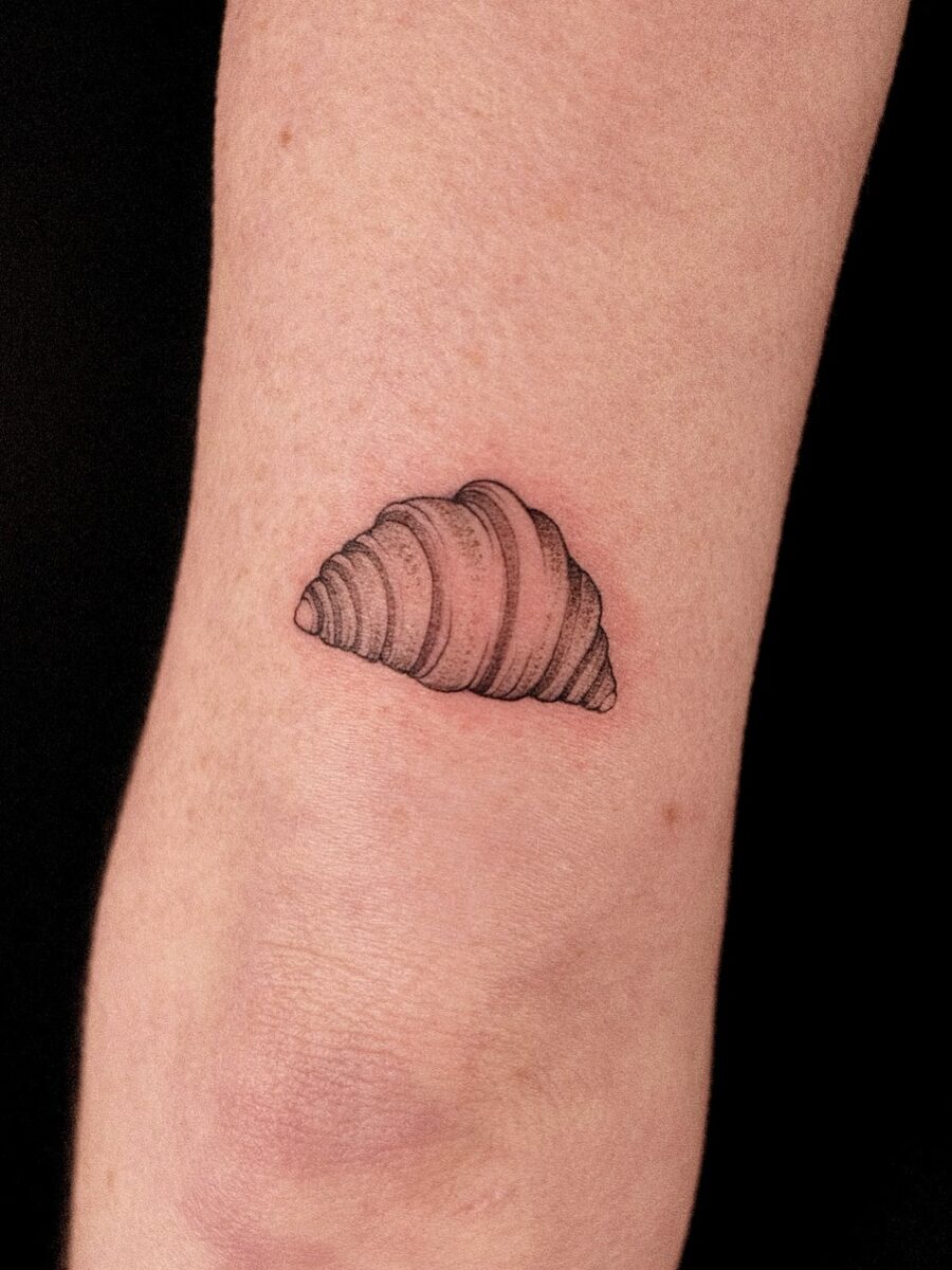 Charming croissant tattoo on the forearm Tattoo on skin