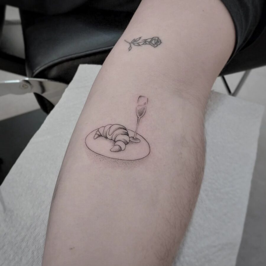 Charming croissant tattoo with a sparkling touch Tattoo on skin