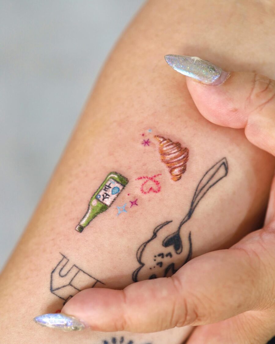 Colorful croissant tattoo with whimsical elements Tattoo on skin