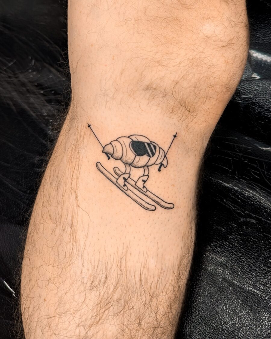 Whimsical skiing croissant tattoo design Tattoo on skin
