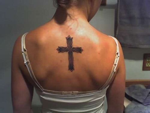 Cute cross tattoo on a girls back Tattoo on skin