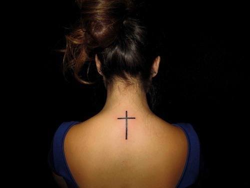 Cute cross tattoo on girl's back Tattoo on skin
