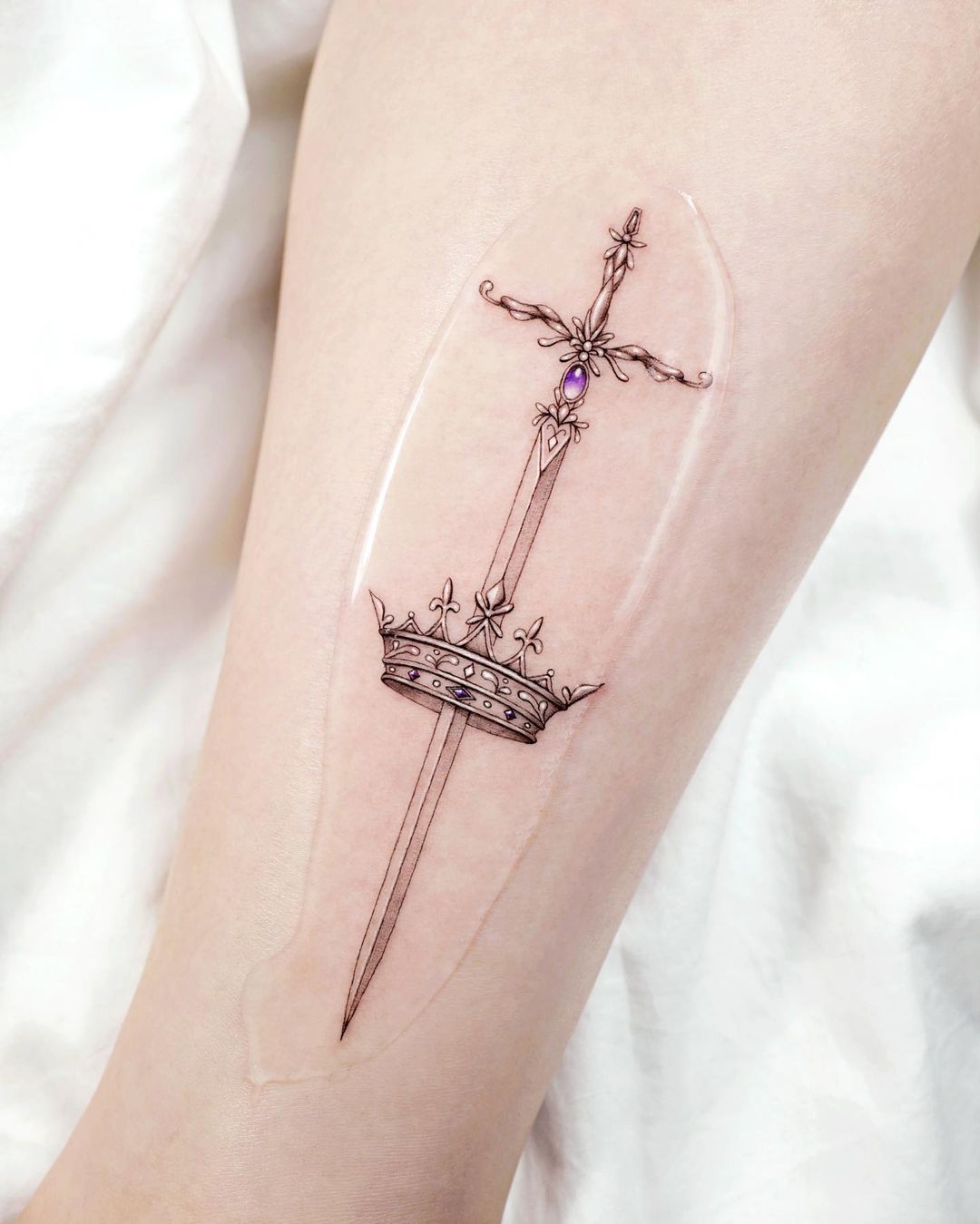 Delicate Sword and Crown Arm Tattoo Tattoo on skin