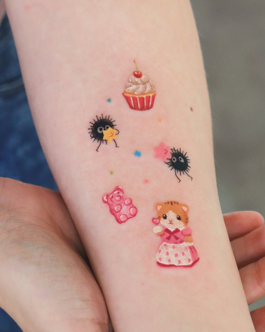 Adorable cupcake tattoo with whimsical characters Tattoo on skin