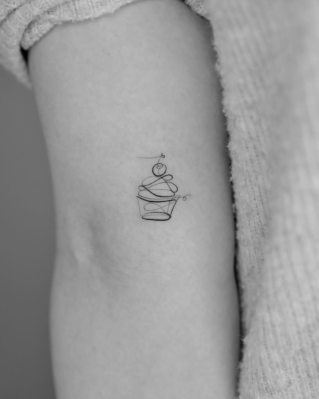Delicate black line art cupcake tattoo design Tattoo on skin
