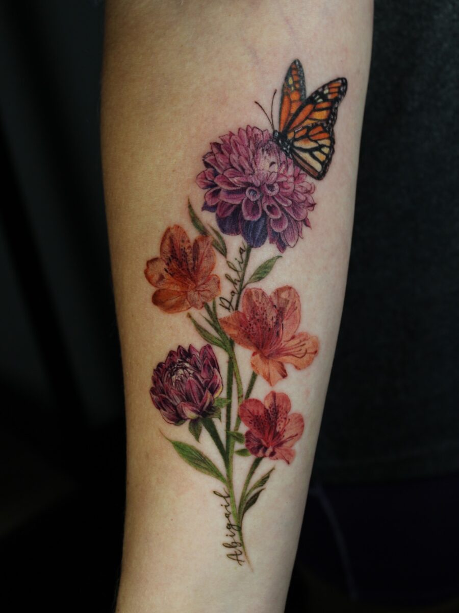 Beautiful dahlia tattoo with vibrant butterfly accents Tattoo on skin