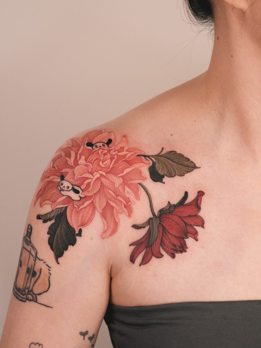 Charming dahlia tattoo with playful panda elements Tattoo on skin