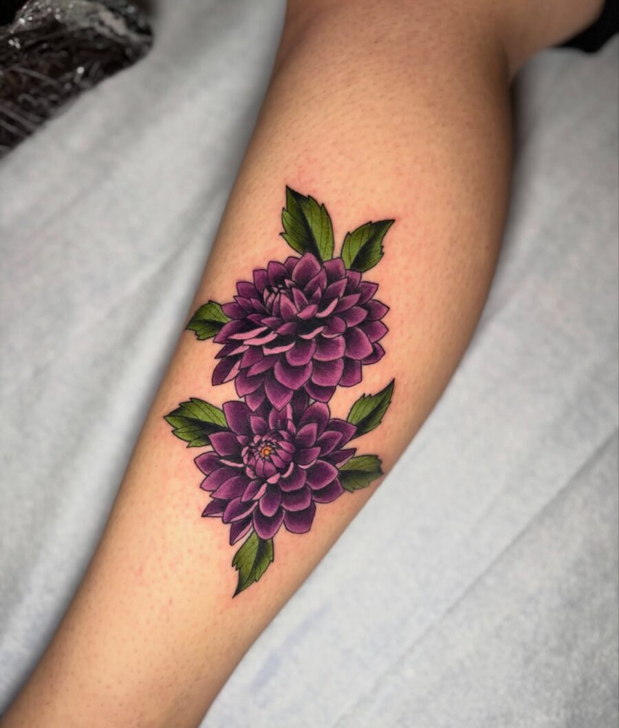 Stunning Purple Dahlia Tattoo with Lush Leaves Tattoo on skin