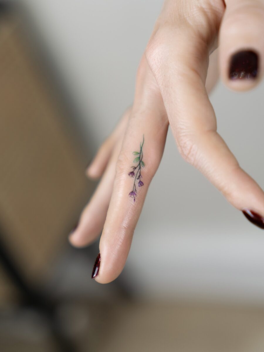 Delicate flower tattoo on fingertip Tattoo on skin