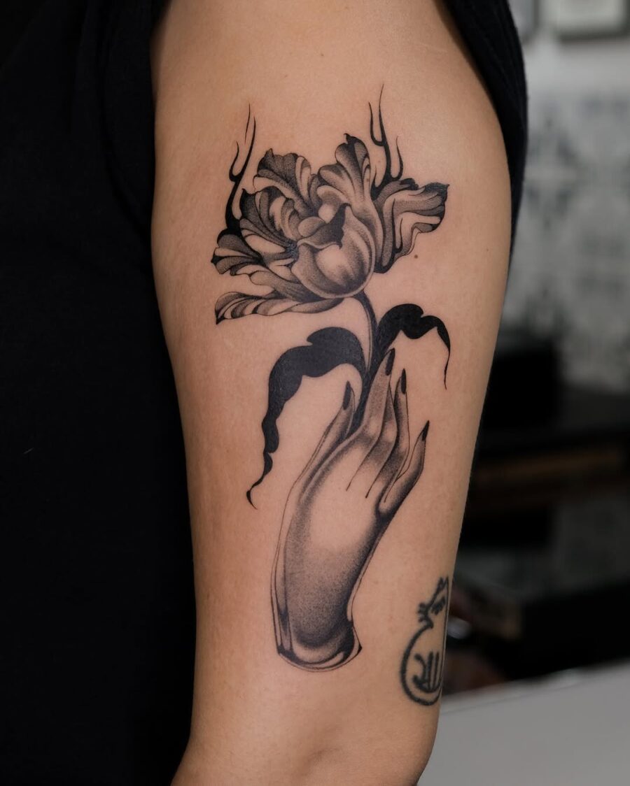 Elegant dead flower tattoo with a hand gesture Tattoo on skin