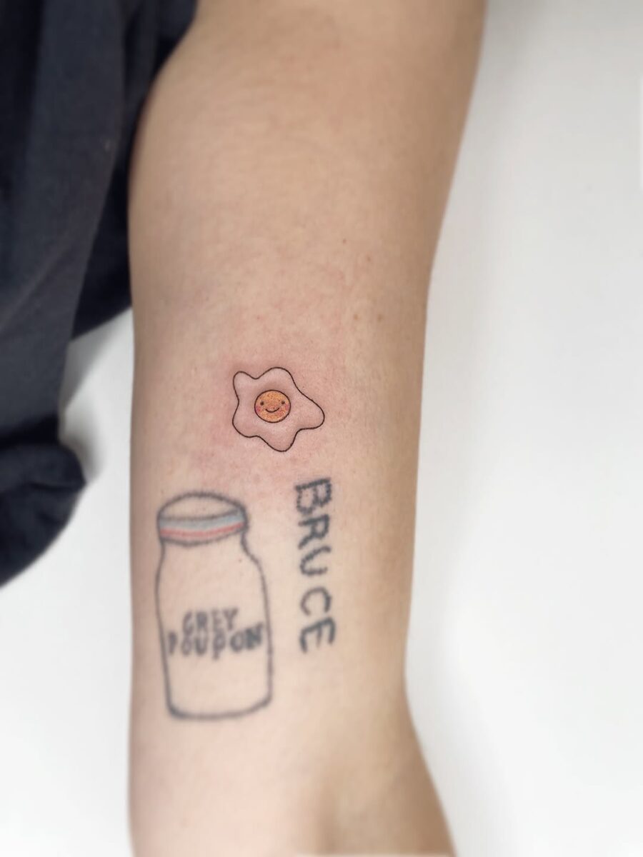 Charming Smiling Egg Tattoo on Arm Tattoo on skin