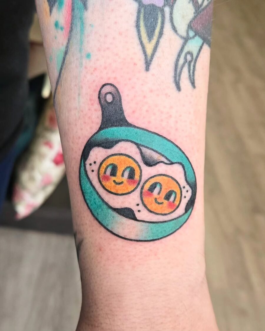 Playful Egg Tattoo in a Skillet Design Tattoo on skin