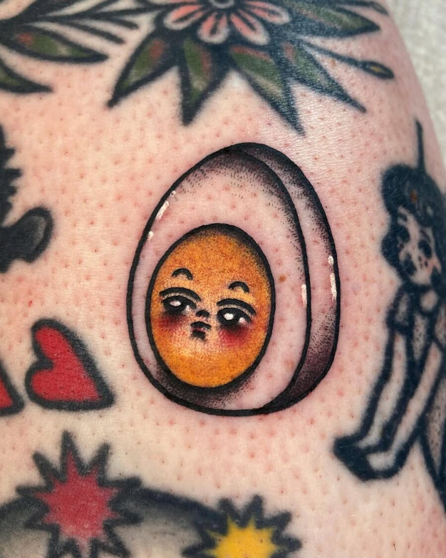 Quirky egg tattoo with expressive face Tattoo on skin