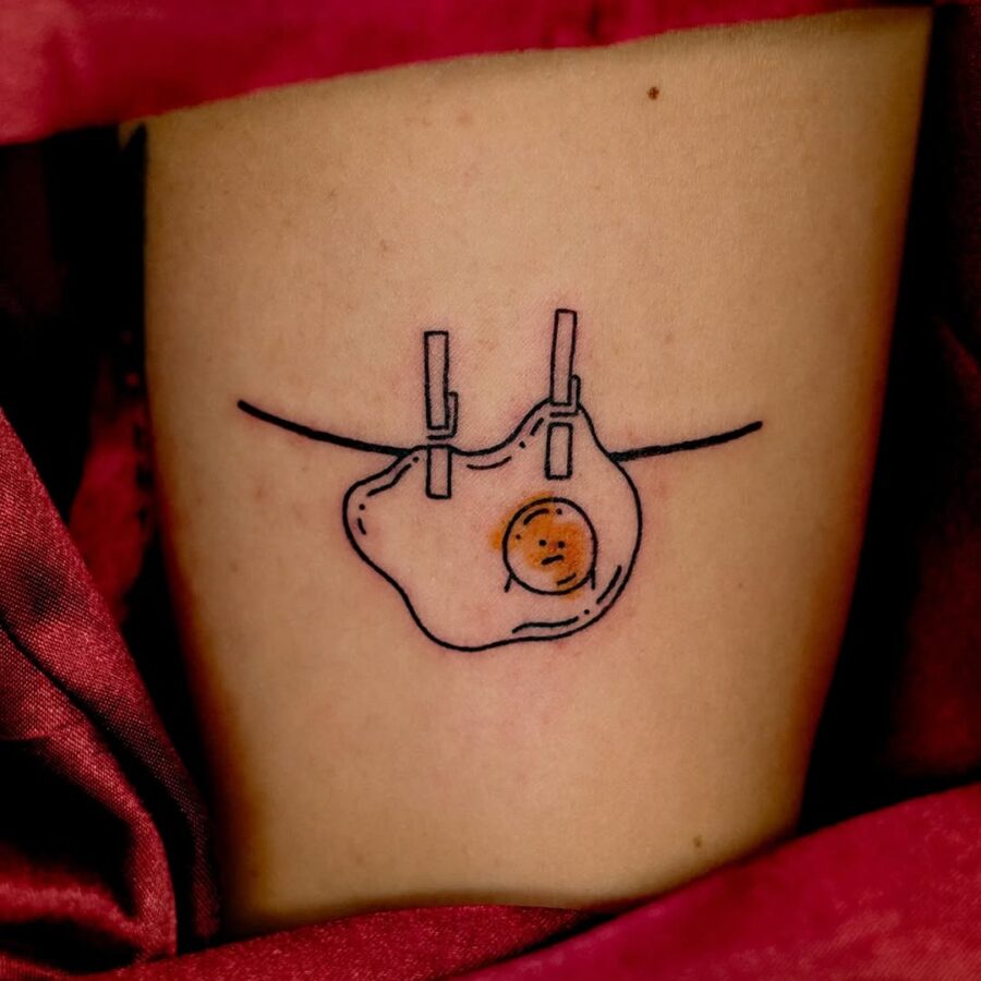 Unique Egg Tattoo with Clothesline Design Tattoo on skin