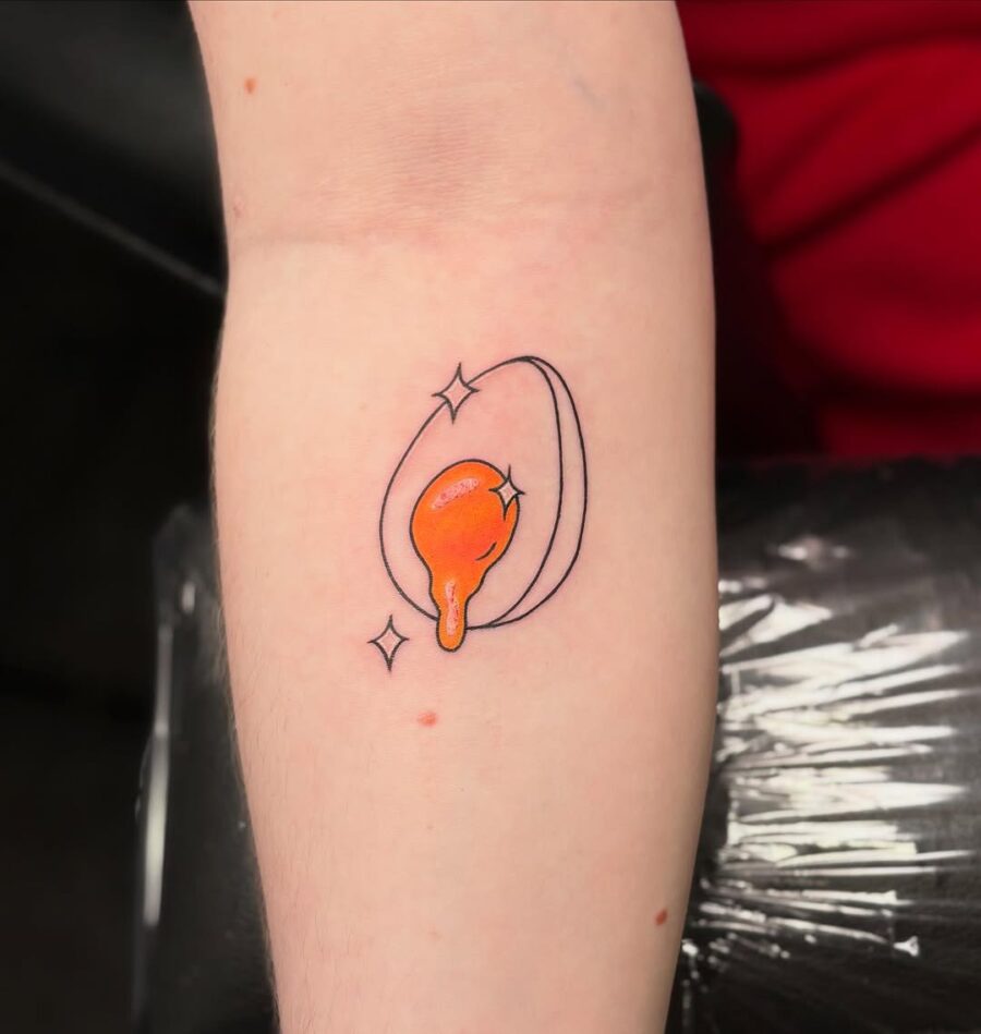 Vibrant Egg Tattoo Design with Sparkles Tattoo on skin