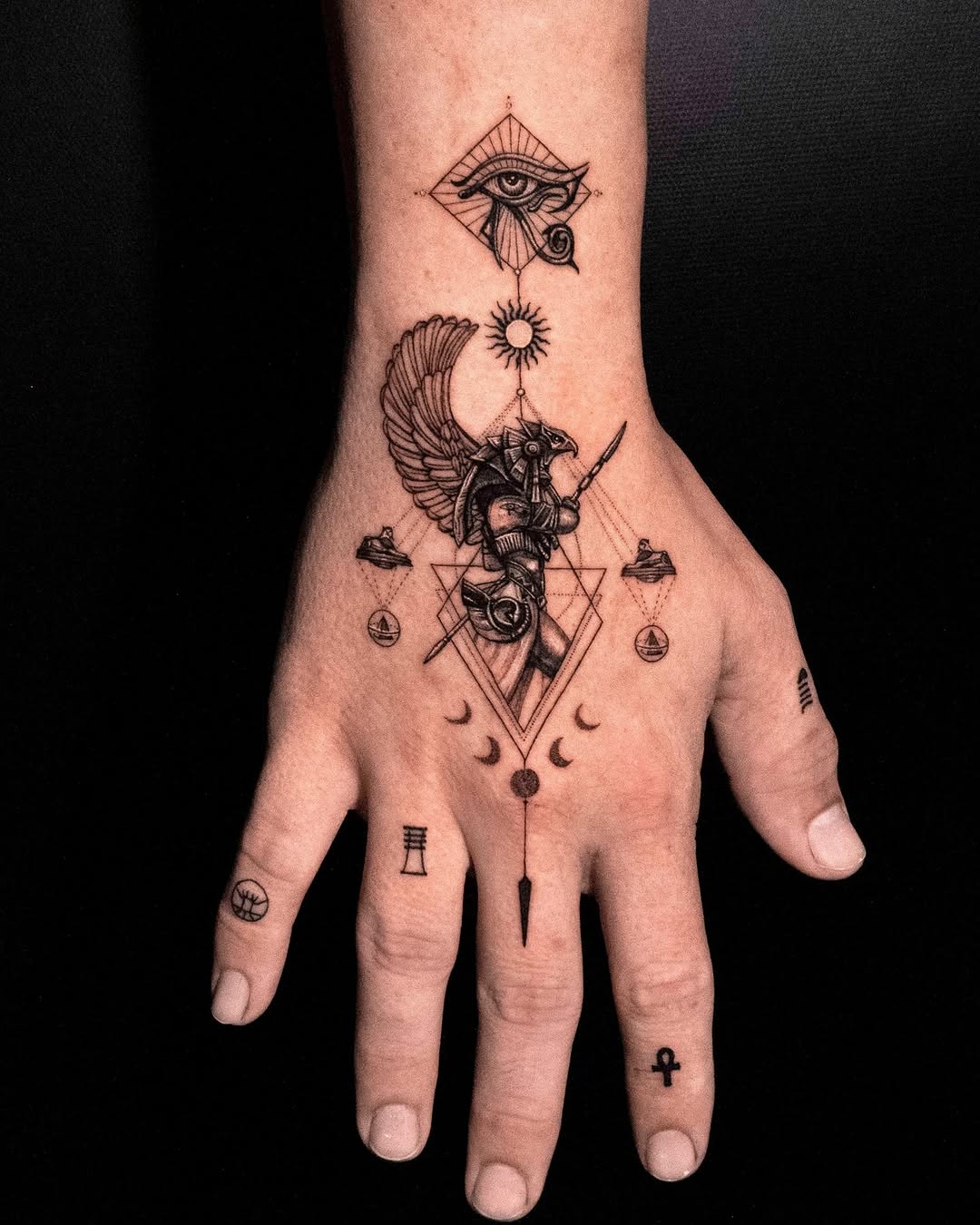 Intricate Egyptian symbols grace this hand tattoo Tattoo on skin