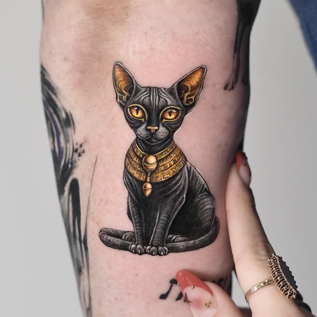 Majestic Egyptian Cat Tattoo with Golden Accents Tattoo on skin