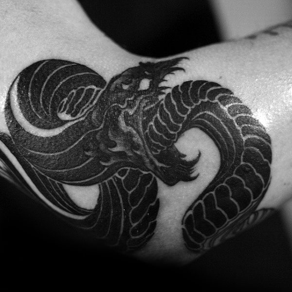 Dramatic Black Ouroboros in Unique Style Elbow Tattoo Ideas Tattoo on skin