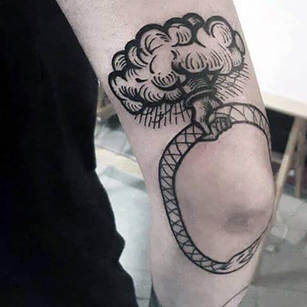 Hand Out of Cloud Holding Ouroboros Elbow Tattoo Tattoo on skin