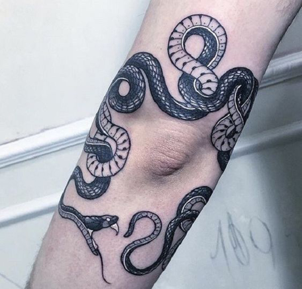 Looped Snake About to Bite Its Tail Elbow Tattoo Tattoo on skin