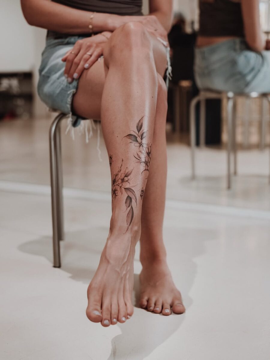 Delicate floral ankle tattoo with leaf accents Tattoo on skin