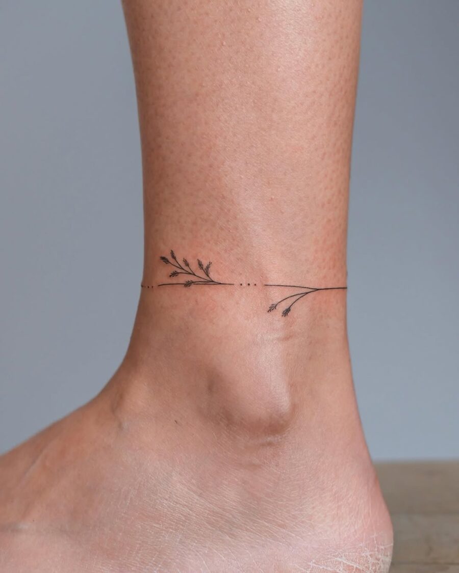 Delicate floral design gracing the ankle. Tattoo on skin