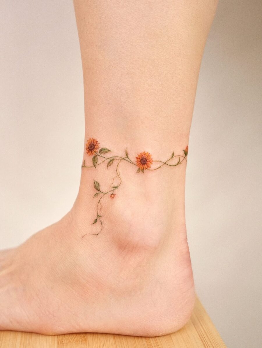 Delicate floral design wrapping around the ankle Tattoo on skin