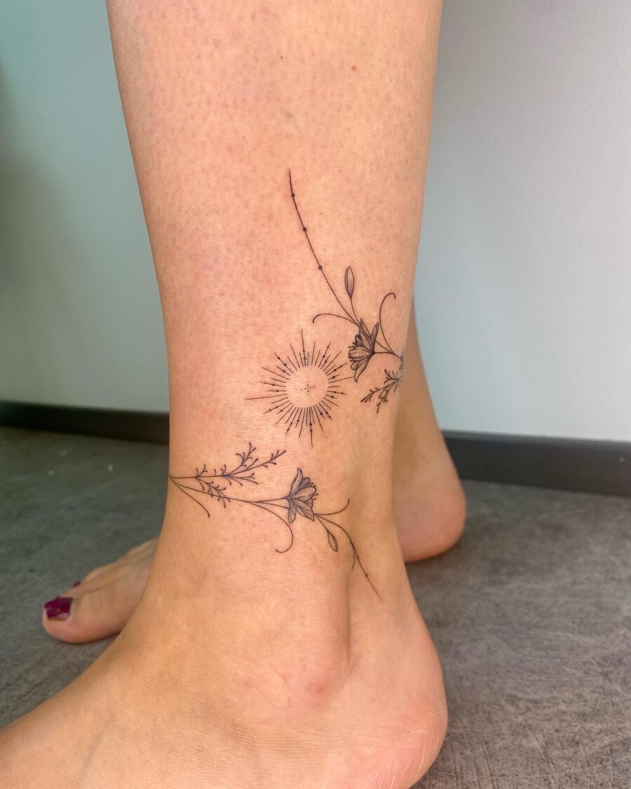 Elegant floral ankle tattoo featuring sun design Tattoo on skin