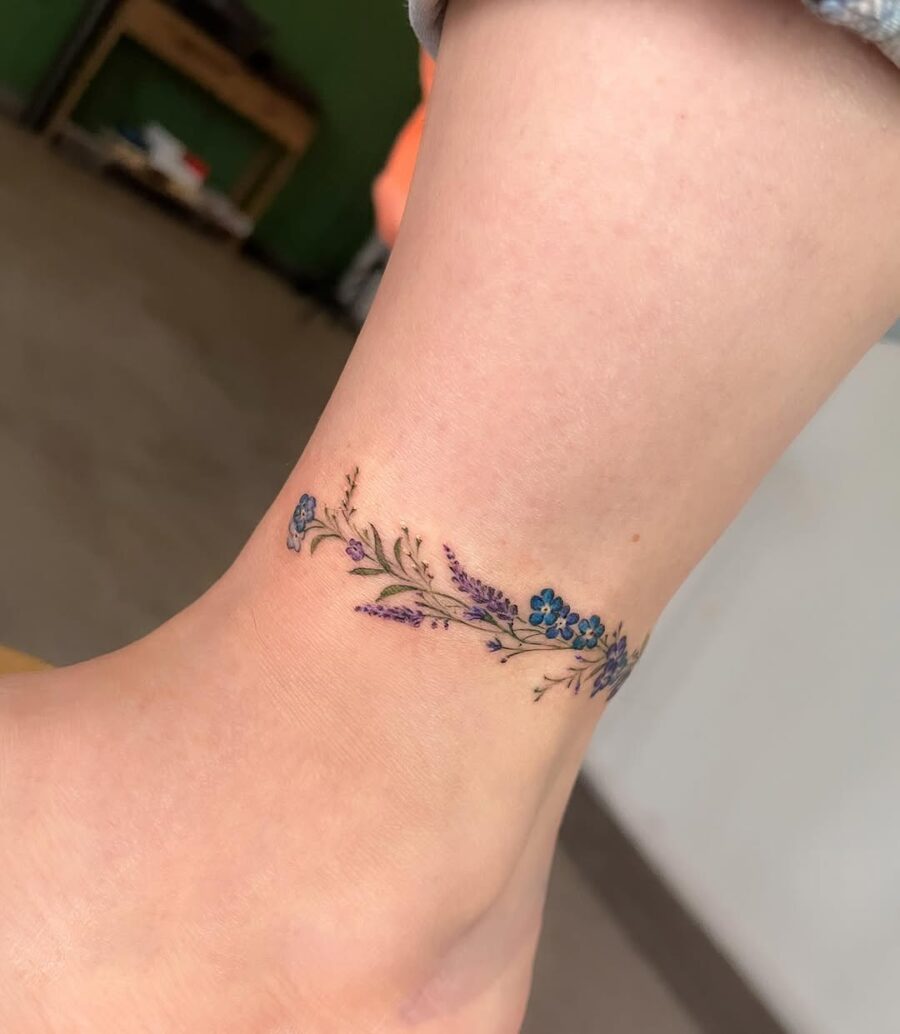 Elegant floral ankle tattoo in vibrant colors Tattoo on skin
