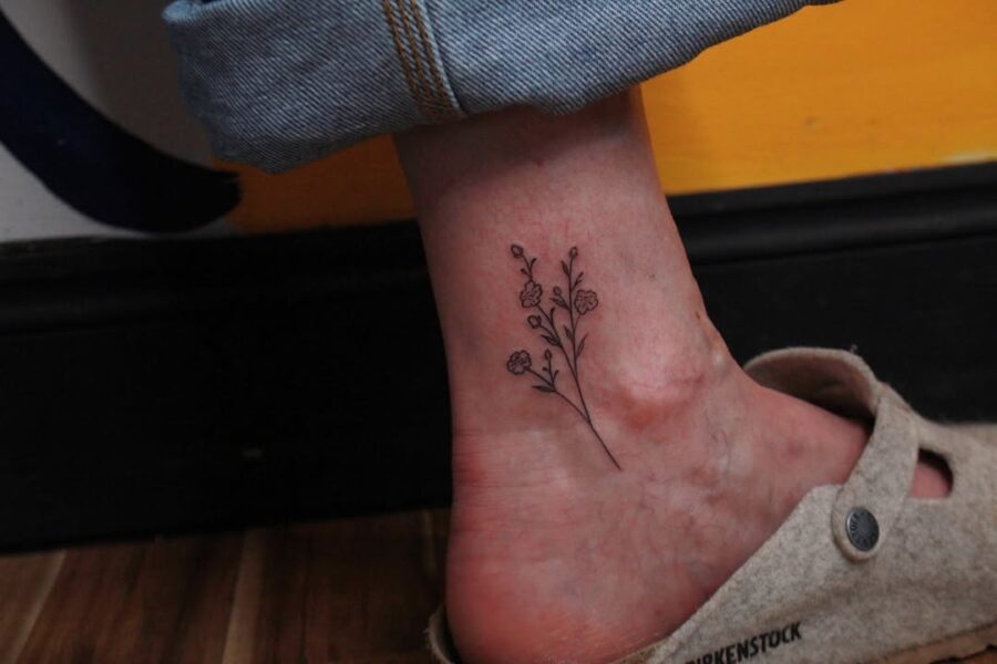 Elegant minimalistic flower ankle tattoo design Tattoo on skin
