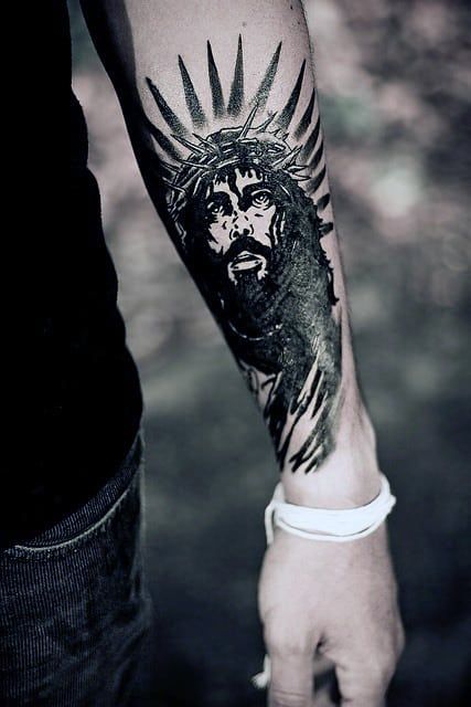 Religious forearm tattoo with a Modern Style Tattoo on skin
