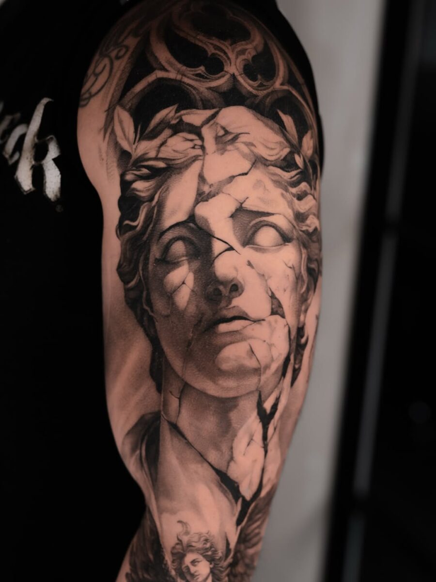 Intricate cracked Greek god tattoo design Tattoo on skin