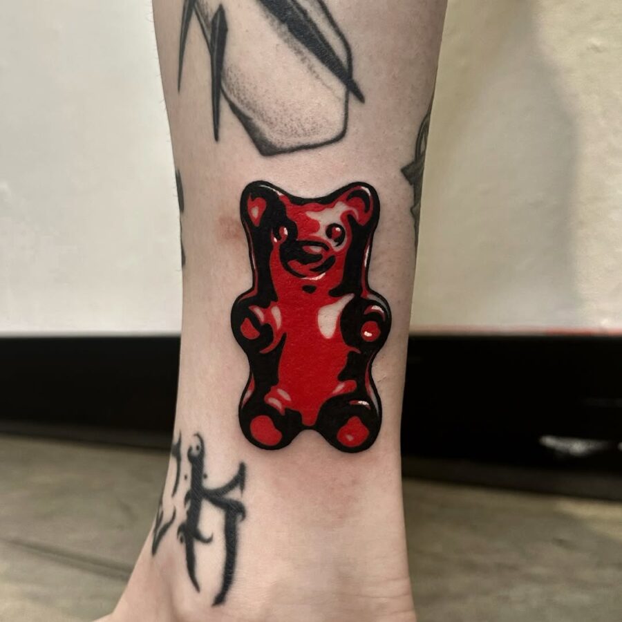 Vibrant red gummy bear tattoo on ankle Tattoo on skin