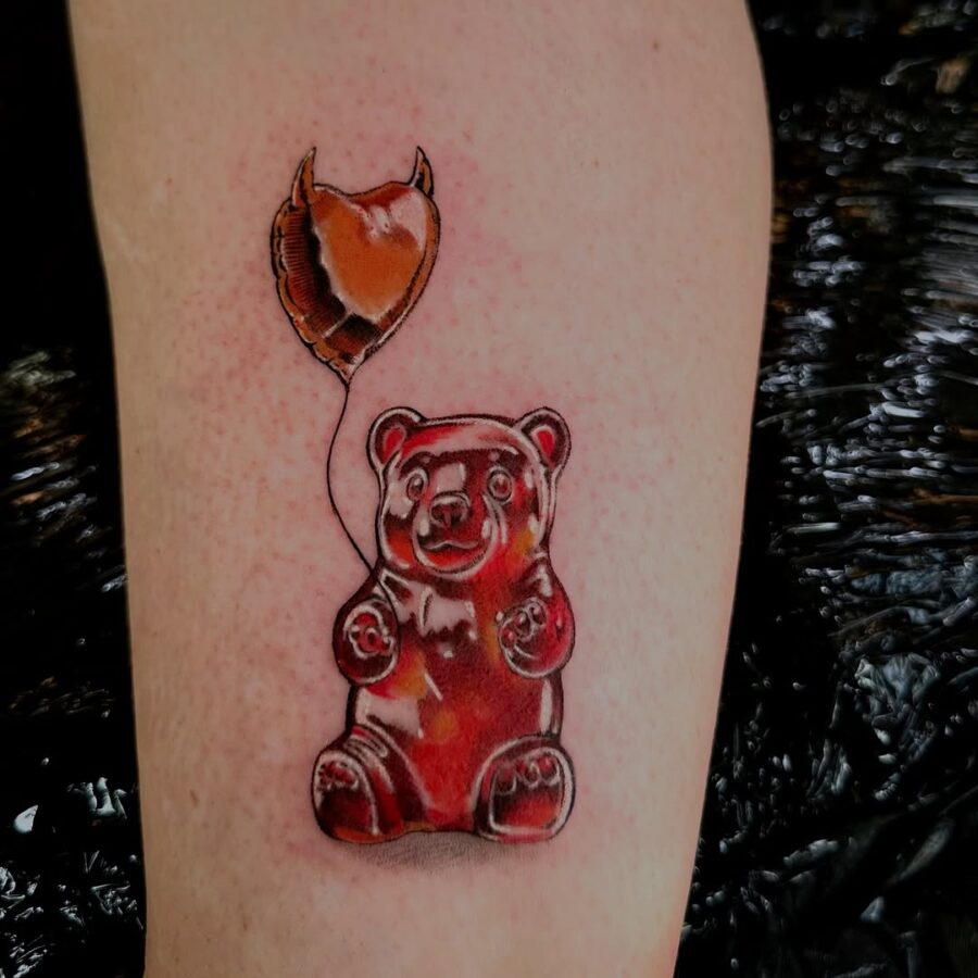Whimsical gummy bear tattoo with a balloon Tattoo on skin