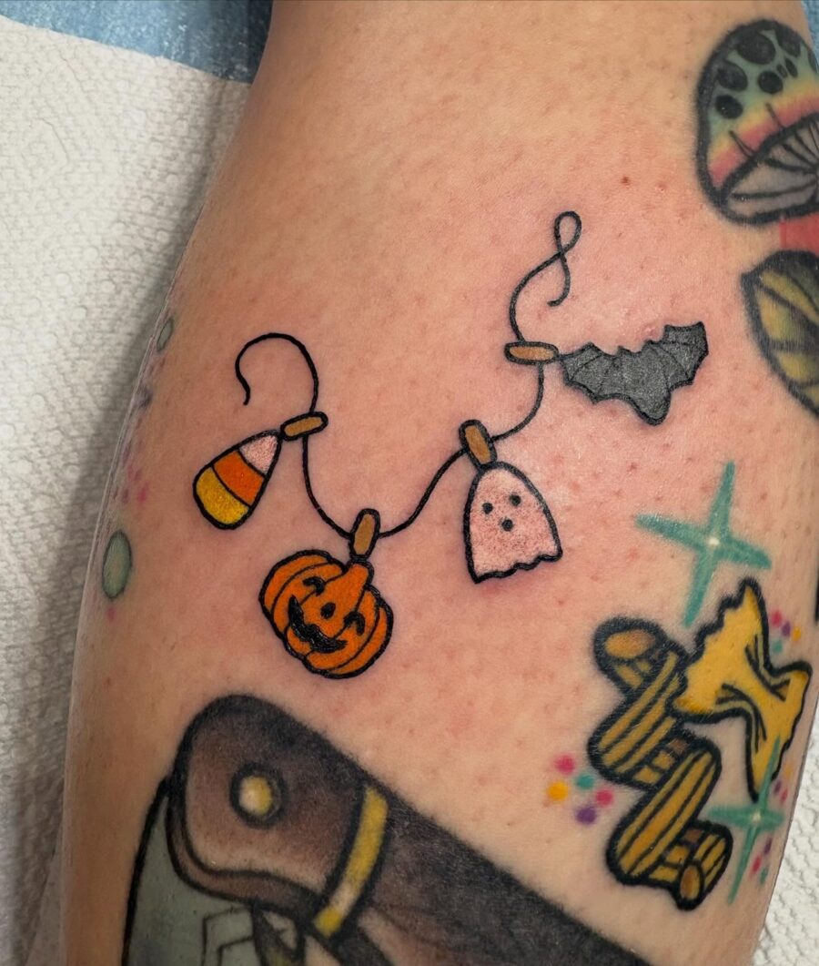 Colorful Halloween-themed tattoo design with charm vibes Tattoo on skin