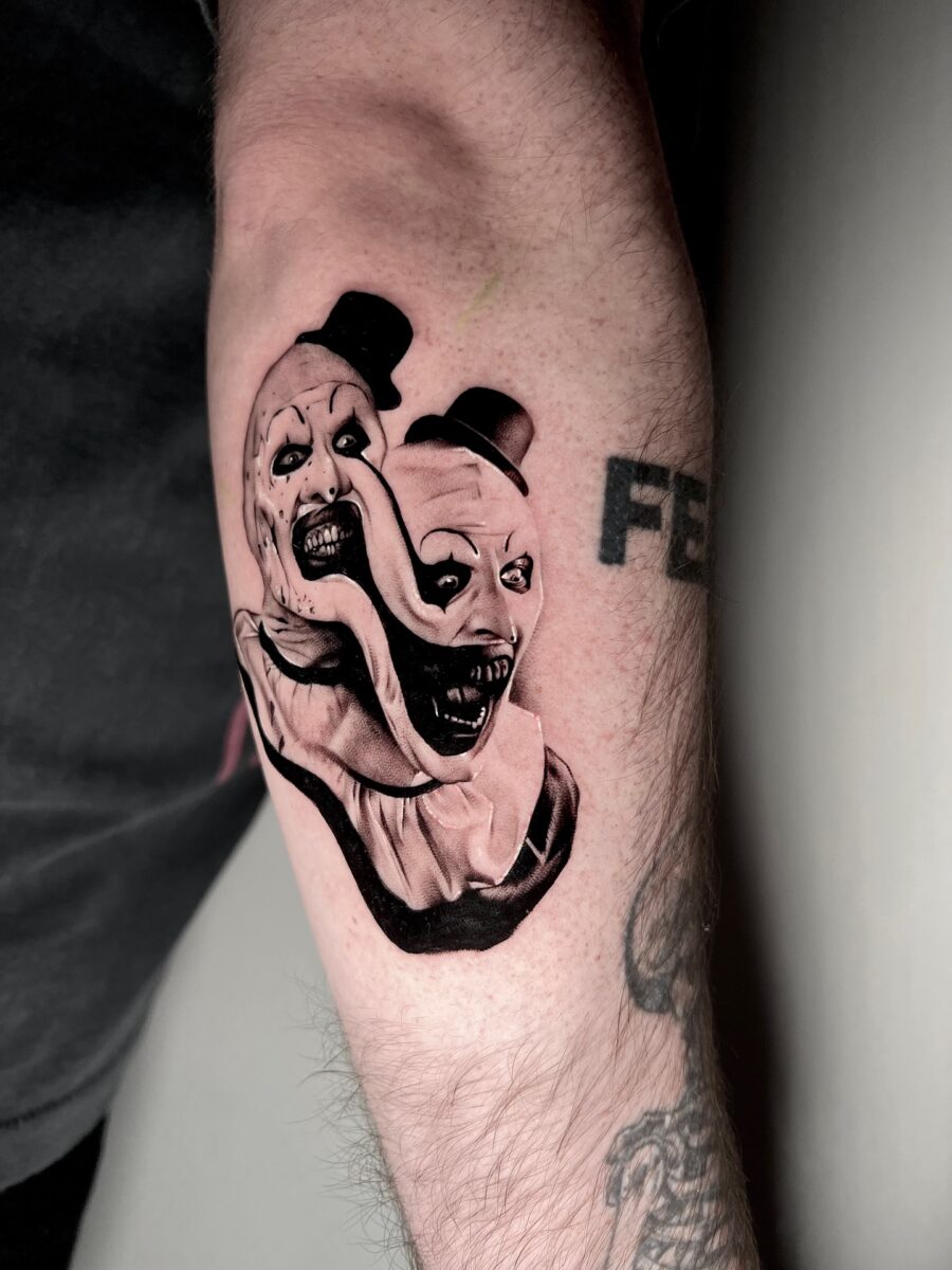 Dual-faced clown tattoo for eerie vibes Tattoo on skin