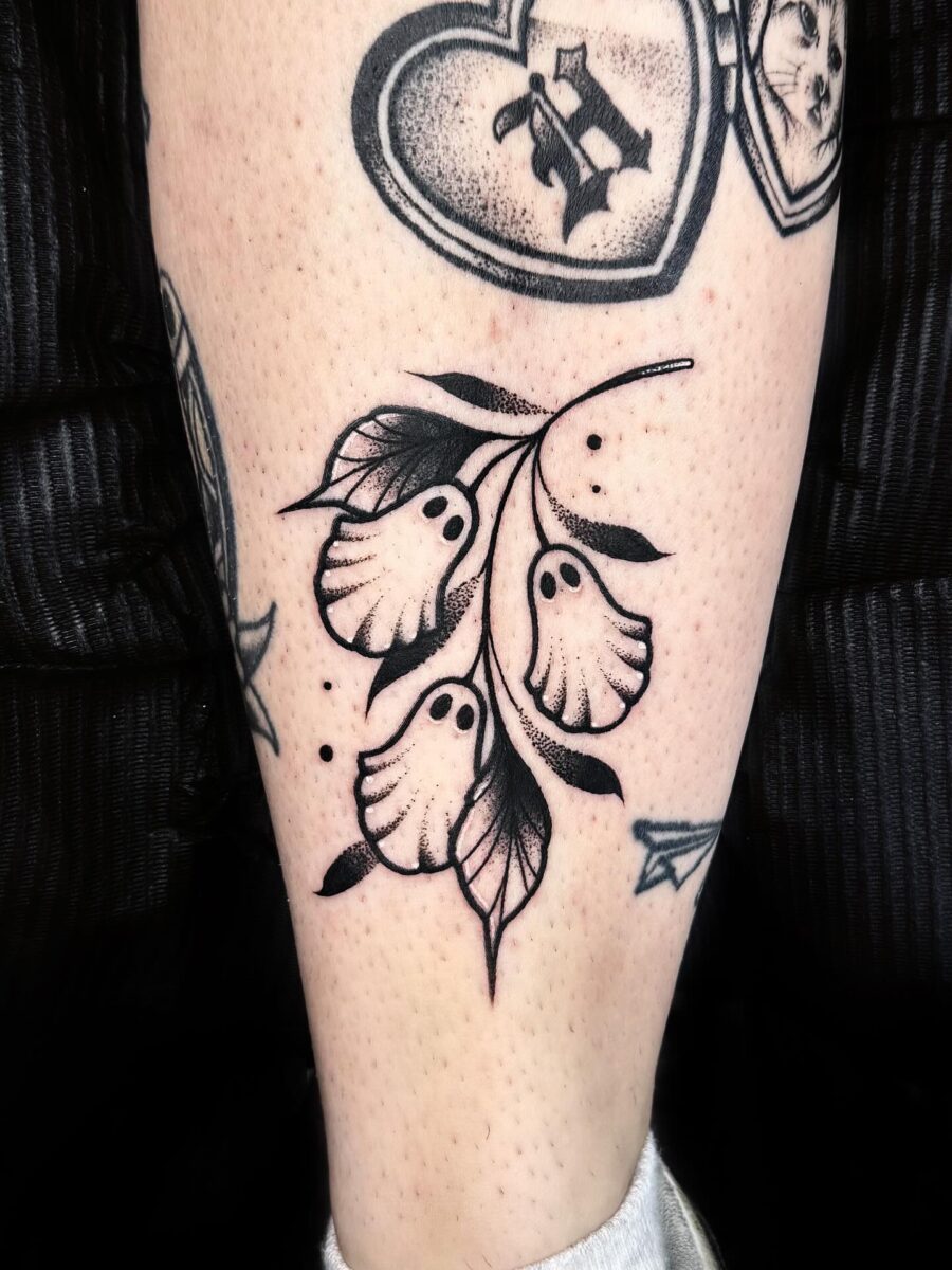 Eerie flora with ghostly elements in tattoo art Tattoo on skin
