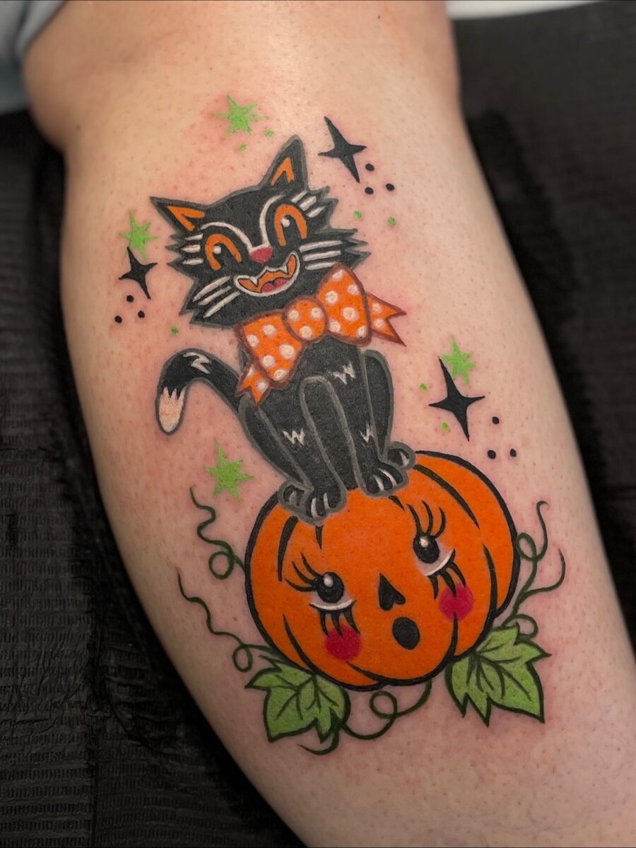 Whimsical black cat atop a pumpkin tattoo Tattoo on skin