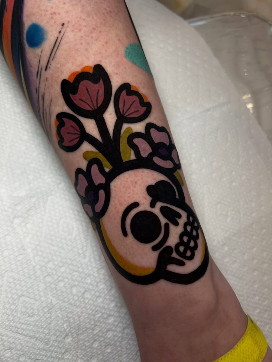 Whimsical skull with floral accents and colors Tattoo on skin